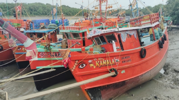 সমুদ্র বন্দরে অপেক্ষায় ট্রলারগুলি নিয়ে মৎস্যজীবিরা