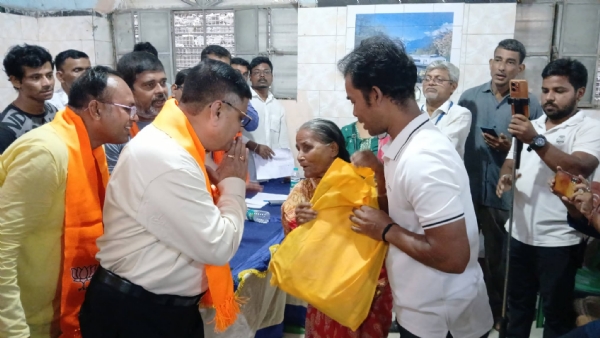 বস্ত্র দান করছেন  মন্ত্রী ভাস্কর ভট্টাচার্য