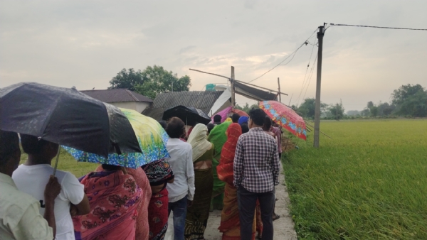 ছাতা মাথায় ভোটারদের লাইন কামারপুকুরের