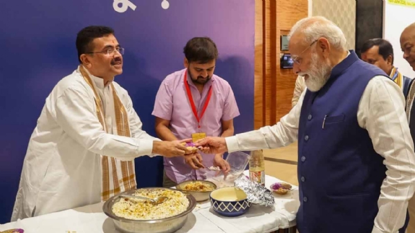 নরেন্দ্র মোদীর হাতে ঝালমুড়ির বাটি তুলে দিচ্ছেন শুভেন্দু অধিকারী